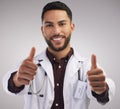 Youre in good hands. a handsome young doctor standing alone in the studio and making a thumbs up hand gesture.