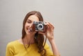 Youre so photogenic. Studio portrait of an attractive young female photographer posing with her camera against a grey Royalty Free Stock Photo