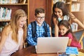 Youre so smart. a group of school children working together on a laptop inside of a library during the day. Royalty Free Stock Photo