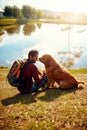 Youre such a good boy. Full length shot of a handsome young man and his dog sitting by a lake in the park. Royalty Free Stock Photo