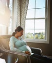 Youre so worth it. a pregnant woman sitting in her living room by herself.