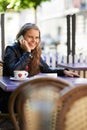 Youre at the wrong cafe. An attractive teen talking on her cellphone while sitting at a bistro. Royalty Free Stock Photo