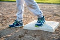 Youth baseball with a runner safe on base with a left foot tagged