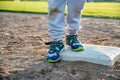 Youth baseball with a runner safe on base with a left foot tagged