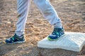 Youth baseball with a runner safe on base with a left foot tagged