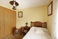 Youth bedroom with single bed, classic wooden furniture and built-in wardrobe with oak wood doors