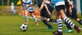 Youth Footballers Running on Grass Football Pitch and Kicking Ball