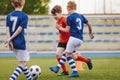 Youth Junior Athletes in Red and Blue Soccer Shirts. Sports Education. Kids Football Players Kicking Ball on Soccer Field. Sports Royalty Free Stock Photo