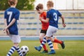 Youth Junior Athletes in Red and Blue Soccer Shirts. Sports Education. Kids Football Players Kicking Ball on Soccer Field. Sports