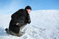 Youth leaning on one knee on snow Royalty Free Stock Photo