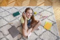 Girl listening to music sitting on the carpet holding phone Royalty Free Stock Photo