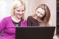 Youth Lifestyle Concepts. Two Happy Expressive Positive Caucaisan Girlfriends Having Fun. Working with Laptop Computer Indoors Royalty Free Stock Photo