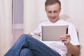 Caucasian Man with Tablet Computer on Couch Royalty Free Stock Photo