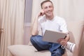 Smiling Handsome Caucasian Man with Tablet Computer on Couch Royalty Free Stock Photo