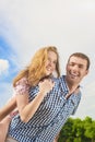 Youth Lifestyle, Summer Vacations, Dating, Love, Happiness Concepts. Happy caucasian Couple Piggybacking Outdoors. Against Nature Royalty Free Stock Photo