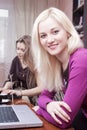 Youth Lifestyle. Two Winsome Positive Laughing Caucaisan Girlfriends Having Fun While Working with Laptop Computer Indoor