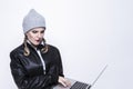Youth Lifestyles. Caucasian Blond Femalr in Warm Hat and Leather Jacket Posing With Laptop With Ingratiating facial Expression on