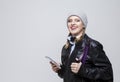 Youth Lifestyles. Portrait of Smiling Happy Caucasian Blond Girl in Warm Hat and Leather Jacket Posing With Cellphone and Backpack