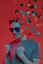 Creative collage of young caucasian man isolated over red background in neon light. Male head consist of puzzle pieces