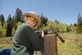 Happy preteen boy shooting muzzleloader in the woods Royalty Free Stock Photo