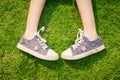 Youth sneakers on girl legs on grass