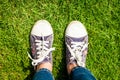 Youth sneakers on girl legs on grass