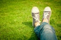 Youth sneakers on girl legs on grass