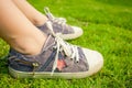 Youth sneakers on girl legs on grass