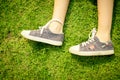 Youth sneakers on girl legs on grass