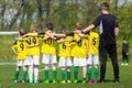 Youth soccer team with coach. Young football team on the pitch.