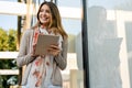 Youth and technology. Attractive young business woman using tablet computer outdoors. Royalty Free Stock Photo