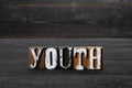 Youth. Word from wooden blocks on a dark textured background
