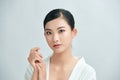 Youthful bright skin pretty Asian woman with hand touching face on white background for beauty concepts