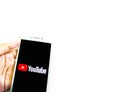 Youtube application icon on smartphone. Hand holding smartphone