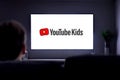 YouTube Kids on television. A little boy on the couch watching a smart TV with the You Tube Kids logo on the screen