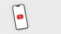Youtube Logo on Mobile Phone Screen on Gray Background with Copy Space