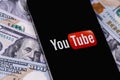 YouTube mobile logo app on screen smartphone iPhone with dollars, money