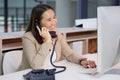 Youve called the right company. a young woman using a telephone and computer in a modern office.