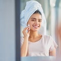 Youve gotta exfoliate. Cropped portrait of a beautiful young woman exfoliating her skin in the bathroom at home.