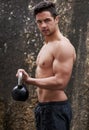 Youve gotta put the work in. Portrait of a handsome young man working out with a kettle bell outside. Royalty Free Stock Photo