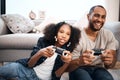 Youve met your match, dad. a young girl playing video games with her father at home. Royalty Free Stock Photo