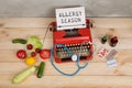 ypewriter with text Allergy season, stethoscope, vegetables, fruits, berries and pills