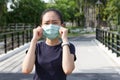 The ypung woman in medical protective mask relaxing in the park.  campaign to use protective mask from COVID19 Royalty Free Stock Photo