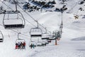 YRENEES, ANDORRA - FEBRUARY 15, 2019: Tourists athletes, skiers and snowboarders on the chair lift of a ski resort. Royalty Free Stock Photo