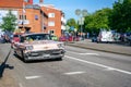 Ystad, Sweden - May 14 2019: Classic cars cruising in the city at Summer Meet . Lots of people standing on the side of the street
