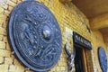 Giant bronze shield and goats head decorates the facade of house in Yuanyang