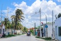 Yucatan Mexico village with motorcycles and a man transporting women in a motorcycle buggy with palm trees and lots of tangled