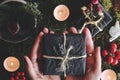 Yule winter solstice Christmas themed flat lay of female hands holding a black gift box