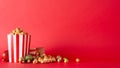 Side view of table decorated with striped popcorn boxes, red, gold and green baubles against a red wall backdrop