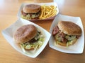 A yummy big lunch with 3 beef burger with french fries on white paper tray on the wood table Royalty Free Stock Photo